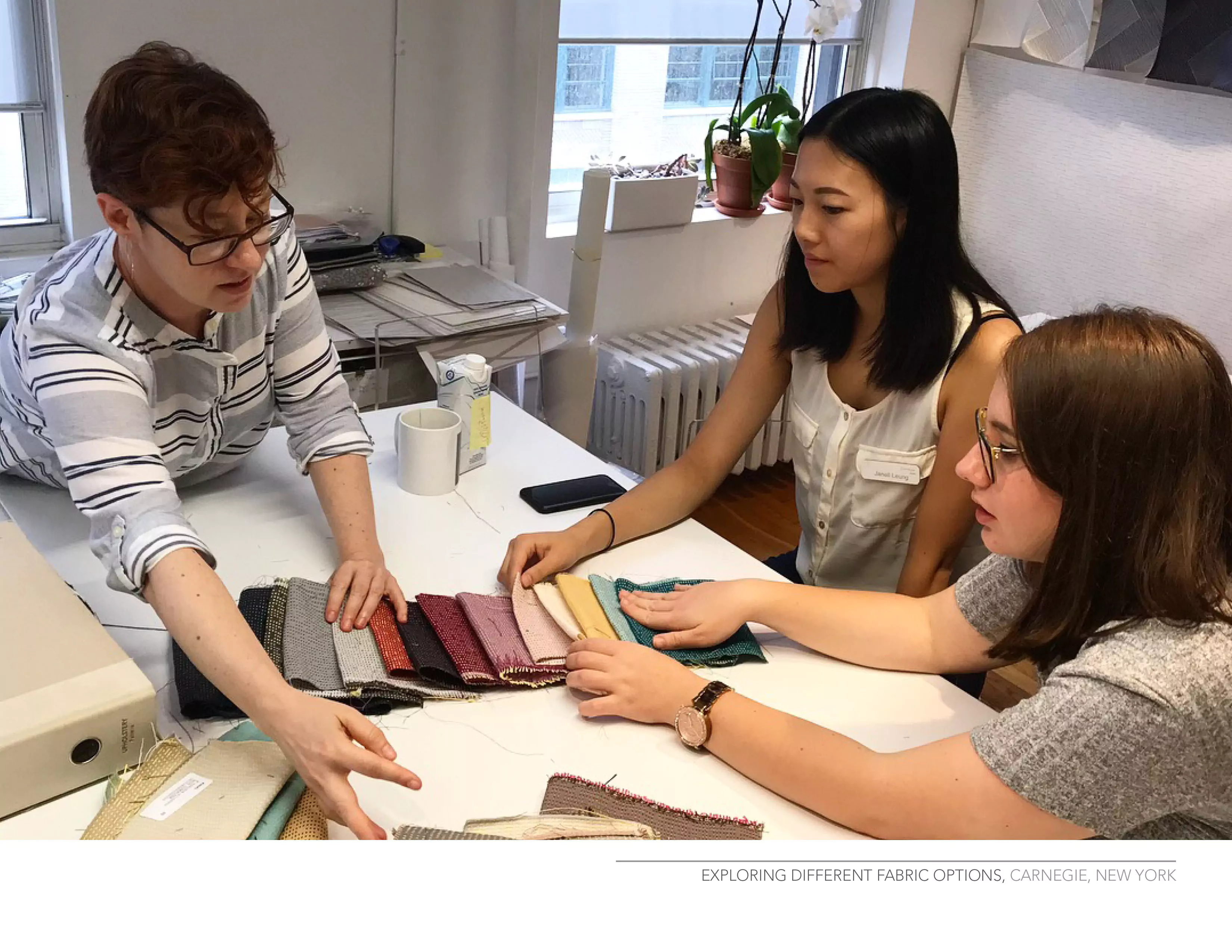 Designers touching sample fabrics within an interior design iniative.